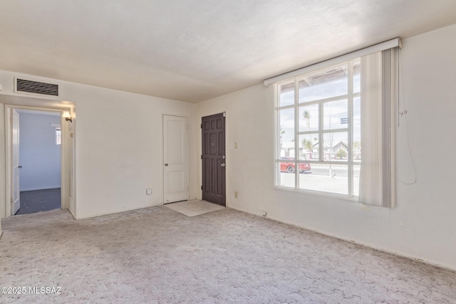 empty room featuring light colored carpet and visible vents