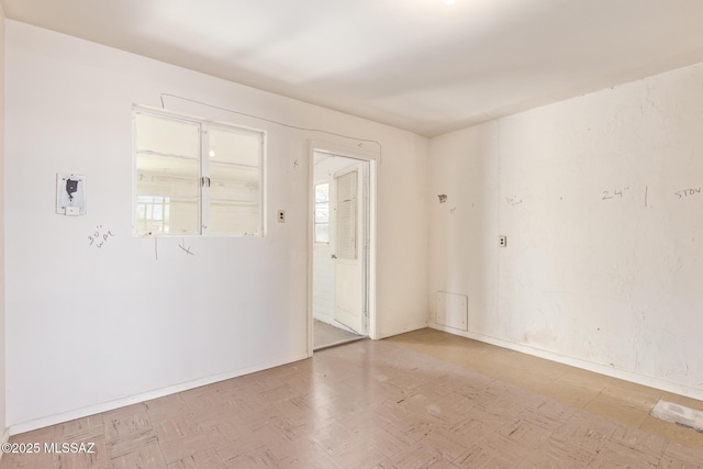 empty room featuring baseboards and tile patterned floors