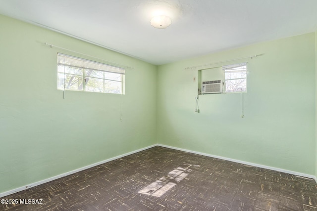 unfurnished room with dark floors, baseboards, and cooling unit