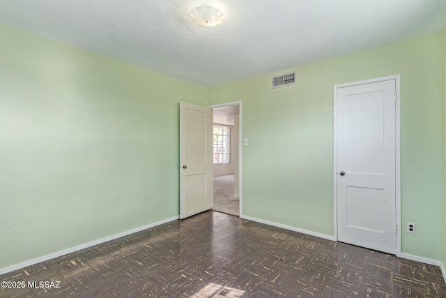 unfurnished bedroom featuring visible vents and baseboards