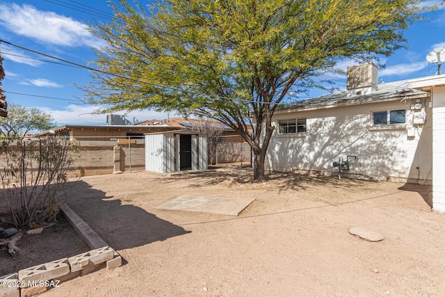 rear view of property with an outdoor structure and fence