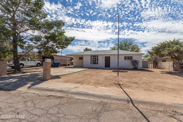 ranch-style home with fence and driveway