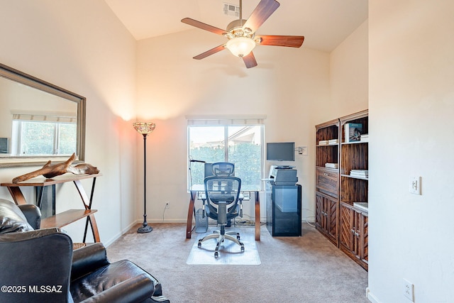 home office with light carpet, high vaulted ceiling, visible vents, and a wealth of natural light