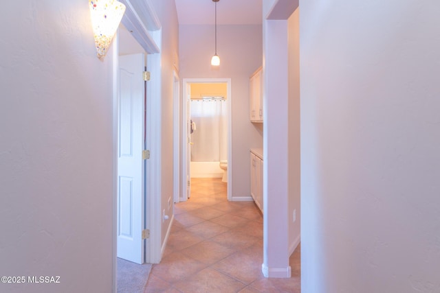 hall with light tile patterned floors and baseboards