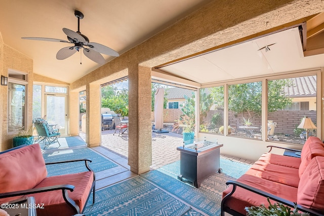 sunroom with lofted ceiling, a healthy amount of sunlight, and a ceiling fan