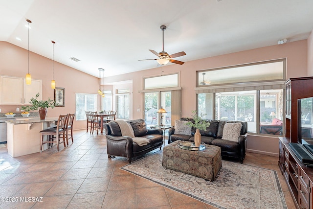 living area with vaulted ceiling, plenty of natural light, visible vents, and a ceiling fan