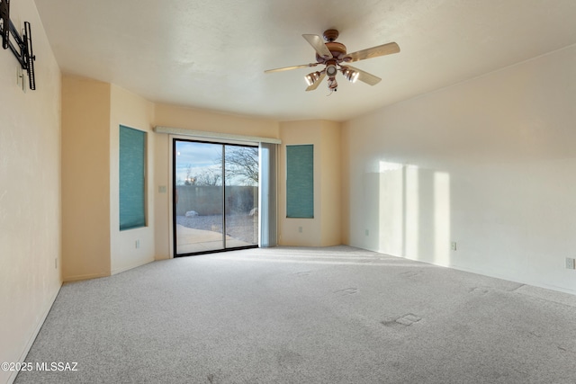 unfurnished room with ceiling fan and carpet