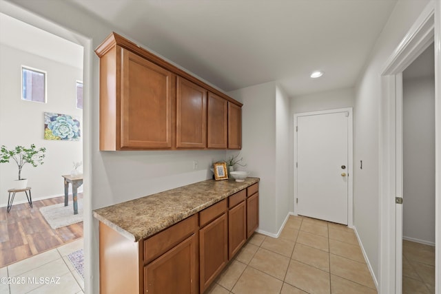 kitchen with recessed lighting, baseboards, brown cabinets, and light tile patterned flooring