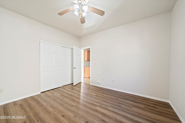 unfurnished bedroom with a closet, baseboards, and wood finished floors