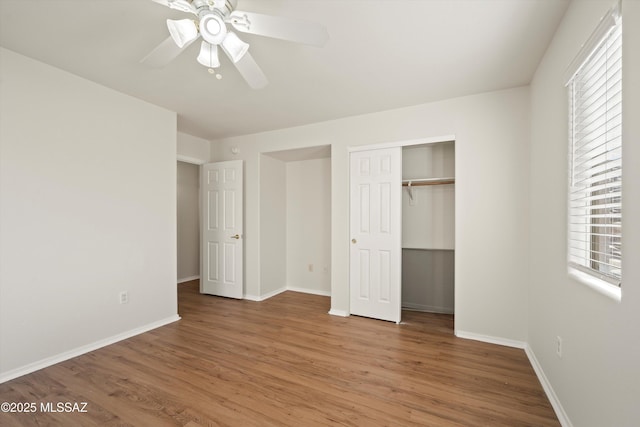 unfurnished bedroom with a ceiling fan, a closet, baseboards, and wood finished floors