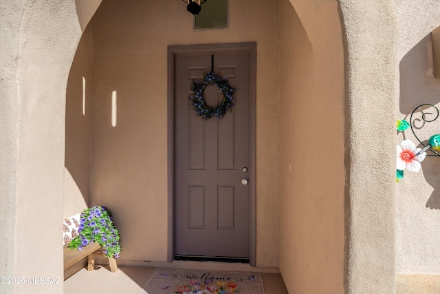 property entrance with stucco siding