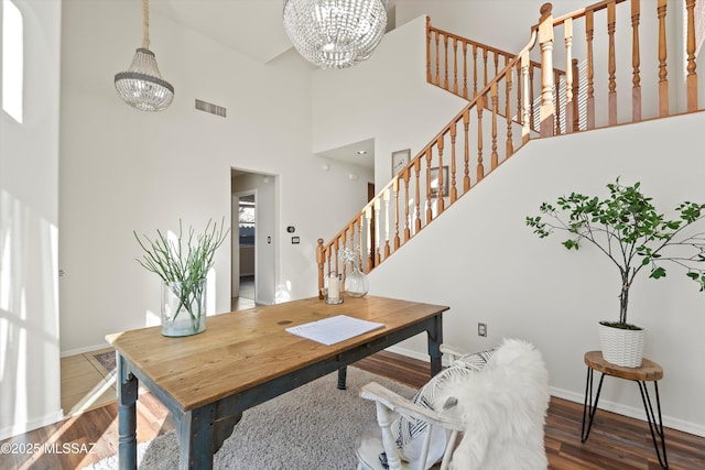 dining area featuring stairs, wood finished floors, visible vents, and a notable chandelier