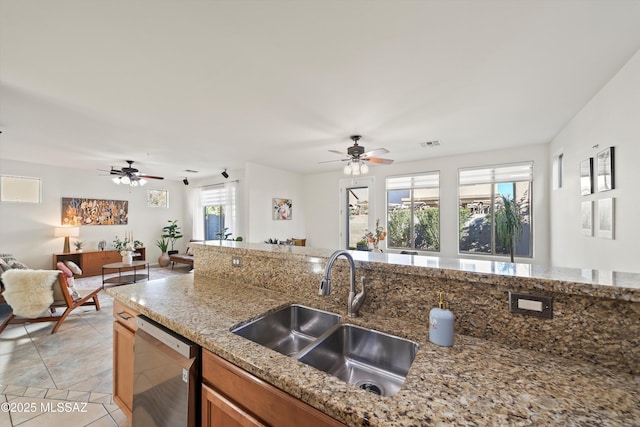 kitchen featuring a sink, visible vents, open floor plan, dishwasher, and brown cabinetry