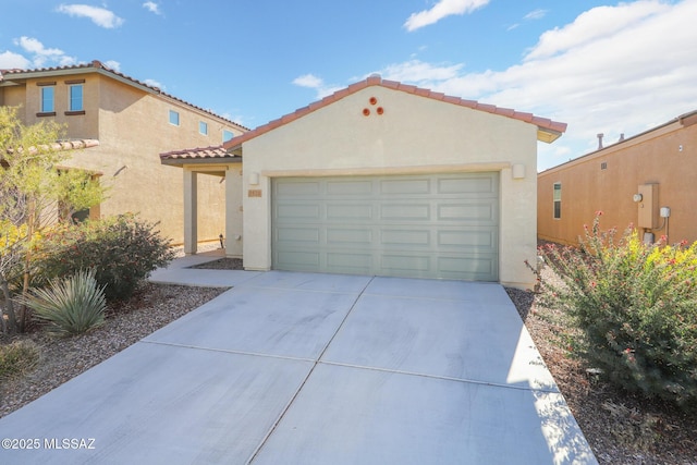 mediterranean / spanish house featuring concrete driveway, a tiled roof, an attached garage, and stucco siding