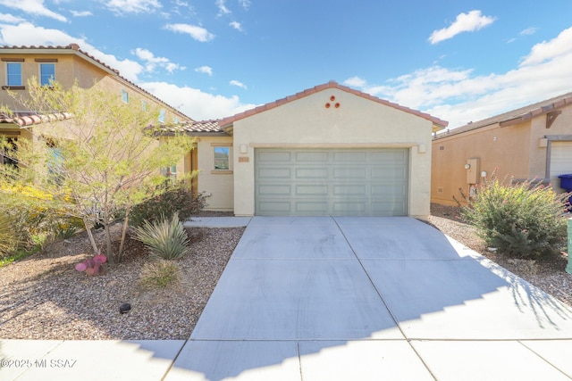 mediterranean / spanish house with a garage, a tile roof, concrete driveway, and stucco siding