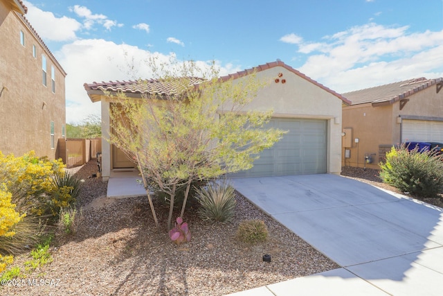 mediterranean / spanish house featuring concrete driveway, a tiled roof, an attached garage, and stucco siding