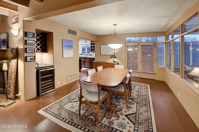 dining space with wine cooler, a dry bar, and visible vents