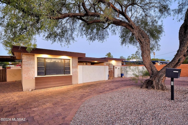 view of front facade featuring brick siding and fence