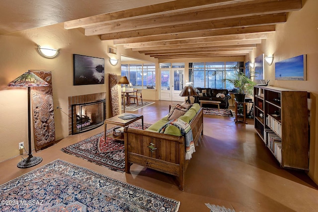 living room featuring a textured wall, beamed ceiling, a fireplace, and visible vents