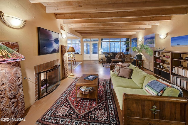 living room featuring a glass covered fireplace, beam ceiling, and visible vents