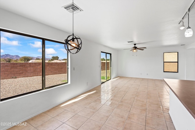 spare room with light tile patterned floors, ceiling fan, visible vents, and rail lighting