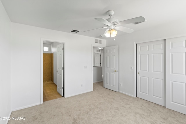 unfurnished bedroom featuring a closet, visible vents, and light colored carpet