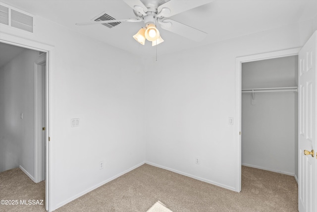 unfurnished bedroom with visible vents, a closet, and light colored carpet