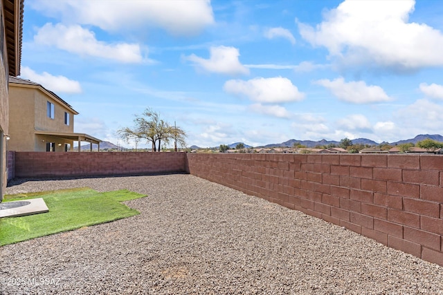 view of yard with a fenced backyard and a mountain view