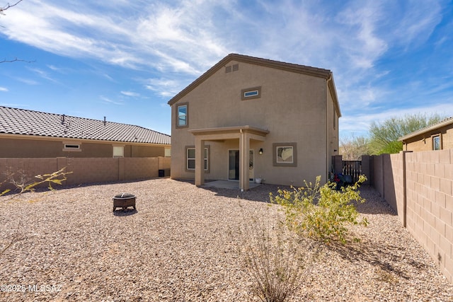 rear view of house with a patio area, a fenced backyard, and stucco siding