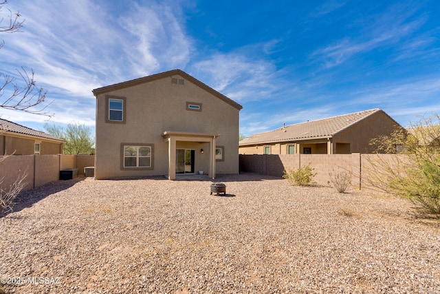 back of property featuring a patio area, a fenced backyard, a fire pit, and stucco siding