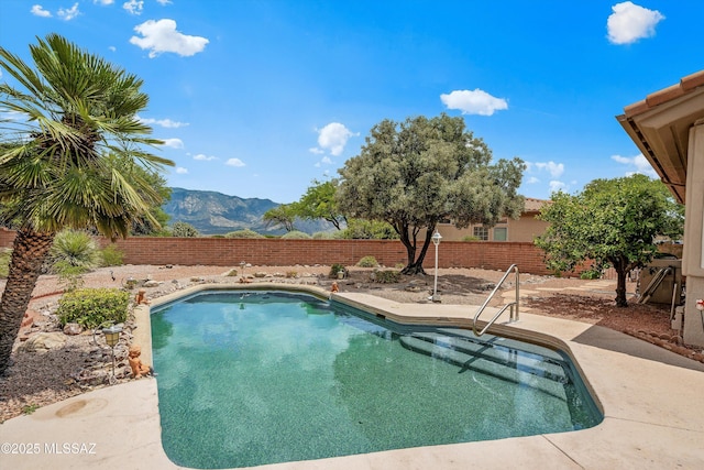 view of pool with a mountain view, a patio, a fenced in pool, and a fenced backyard