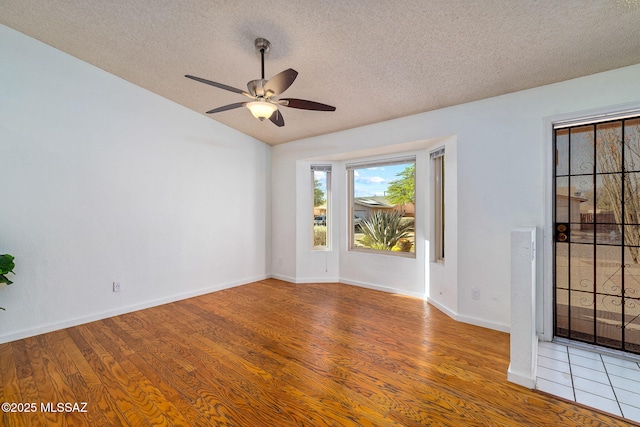 9990 E Mary Dr, Tucson, AZ 85730 - empty room featuring a textured ceiling, vaulted ceiling, baseboards, a ceiling fan, and wood finished floors