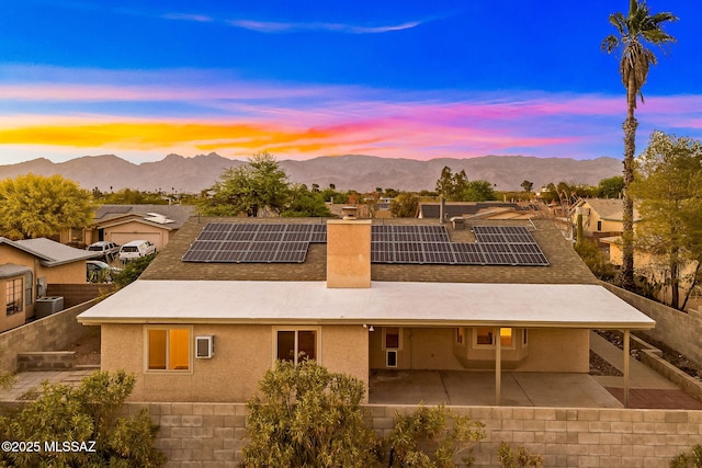 9990 E Mary Dr, Tucson, AZ 85730 - rear view of house with roof mounted solar panels, a patio area, and a mountain view
