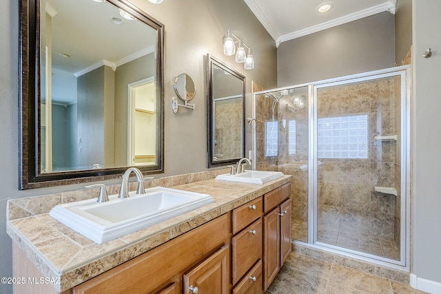 full bathroom featuring a shower stall, double vanity, a sink, and crown molding