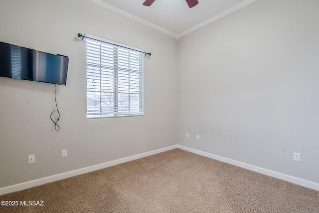 carpeted spare room featuring ceiling fan, ornamental molding, and baseboards