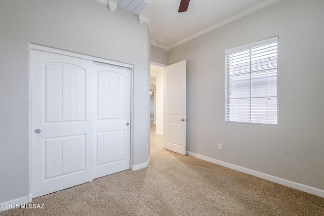 unfurnished bedroom featuring a closet, multiple windows, crown molding, and carpet flooring