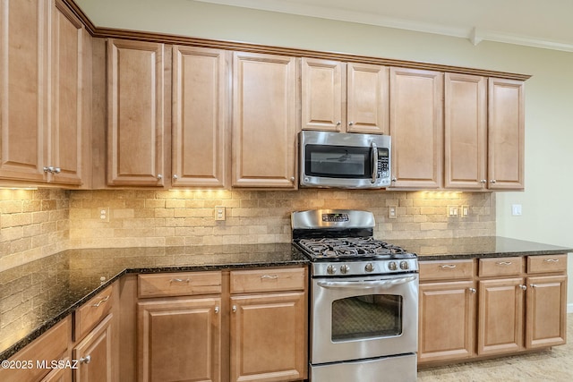 kitchen featuring dark stone countertops, appliances with stainless steel finishes, decorative backsplash, and crown molding