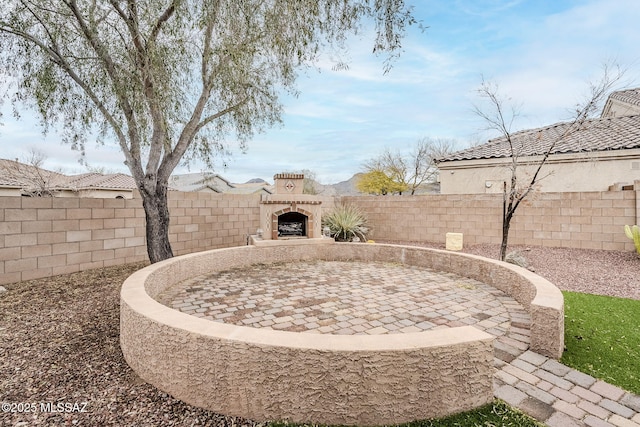view of yard with a patio area, a fenced backyard, and exterior fireplace