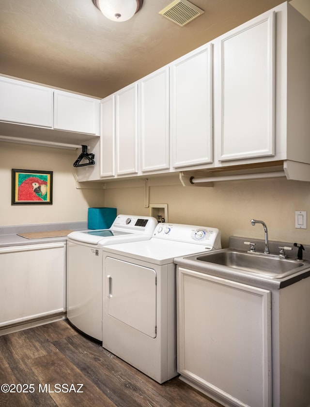 washroom with separate washer and dryer, a sink, visible vents, cabinet space, and dark wood finished floors