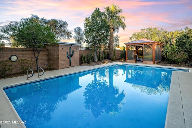 view of pool with a gazebo and a fenced backyard