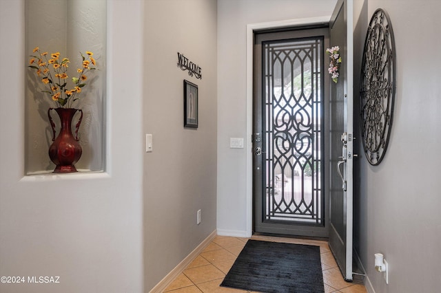 entryway with light tile patterned floors and baseboards