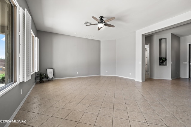 spare room featuring light tile patterned floors, ceiling fan, visible vents, and baseboards