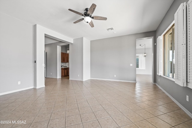 spare room with light tile patterned floors, baseboards, visible vents, and a ceiling fan