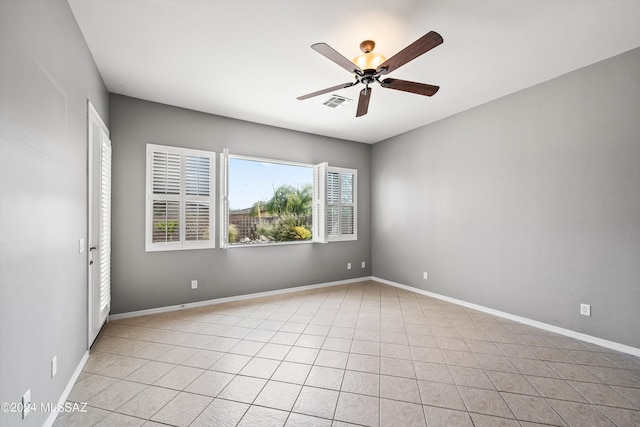 empty room featuring visible vents, ceiling fan, baseboards, and light tile patterned floors