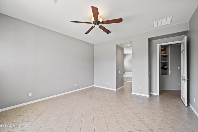 unfurnished bedroom with light tile patterned floors, baseboards, visible vents, ceiling fan, and ensuite bathroom