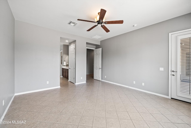 unfurnished bedroom with light tile patterned floors, connected bathroom, visible vents, and baseboards