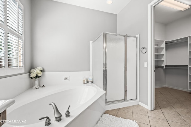 bathroom featuring a shower stall, a walk in closet, a bath, and tile patterned floors