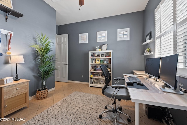 home office featuring light tile patterned flooring, ceiling fan, and baseboards