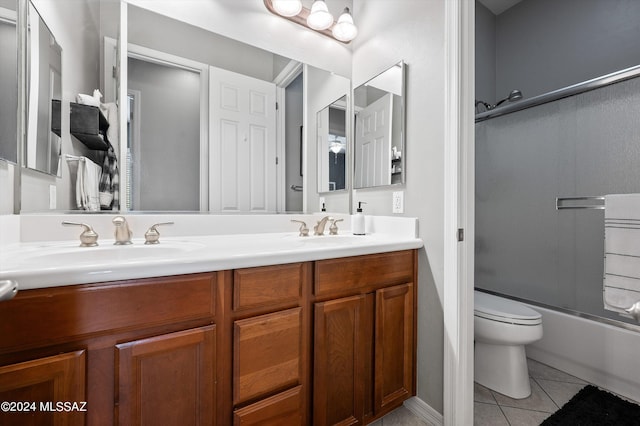 bathroom with tile patterned flooring, a sink, toilet, and double vanity