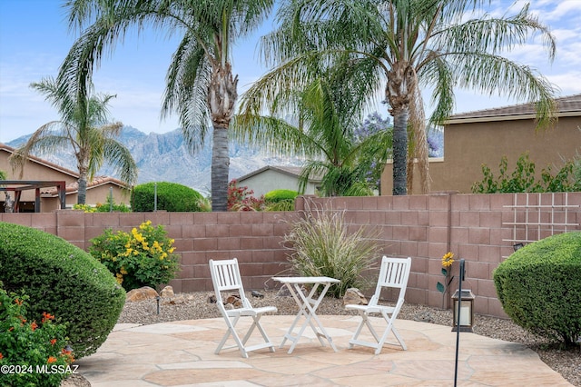 view of patio featuring fence and a mountain view